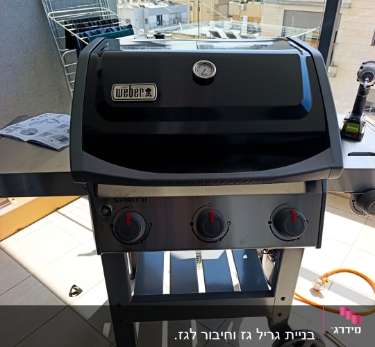 גריל גז של וובר עם שלושה כפתורים על מרפסת
